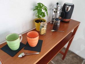 una mesa de madera con tazas y cucharas. en Palmetto Lodge en Playa San Miguel 