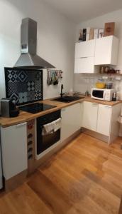a kitchen with white cabinets and a stove top oven at CŒUR MENOU, Radis'son & PARKING in Nantes