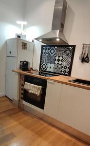 a kitchen with a stove and a refrigerator at CŒUR MENOU, Radis'son & PARKING in Nantes