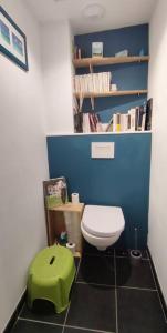 La petite salle de bains est pourvue de toilettes et d'un tabouret vert. dans l'établissement CŒUR MENOU, Radis'son & PARKING, à Nantes