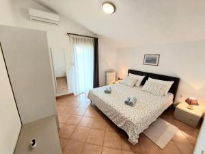 1 dormitorio con 1 cama con edredón blanco en Apartments Terranova, en Rovinj