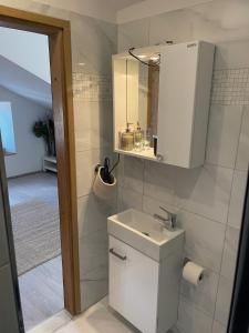 a white bathroom with a sink and a mirror at FREDYs APARTMENTs in Stari Grad