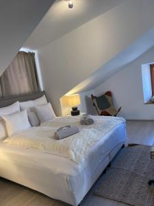 ein Schlafzimmer mit einem großen weißen Bett und einem Stuhl in der Unterkunft FREDYs APARTMENTs in Stari Grad