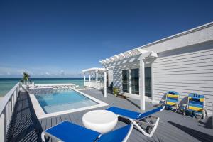 a deck with blue chairs and a swimming pool at Caribbean SandCastle home in James Cistern