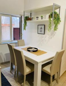 a dining room with a white table and chairs at Montesanto House Palermo in Palermo