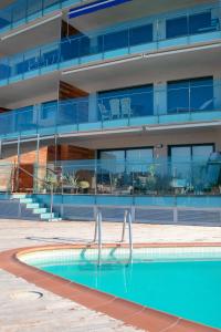 una piscina frente a un edificio en Moderno y confortable apartamento Port Trebol en Roses