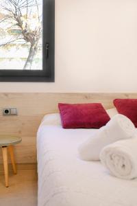 2 camas en una habitación con almohada roja en Moderno y confortable apartamento Port Trebol en Rosas
