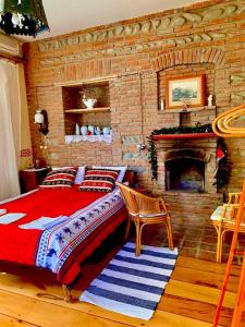 泰拉維的住宿－Dzveli Galavani -Old Wall，一间卧室设有砖墙、一张床和一个壁炉