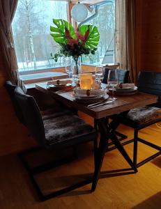 einen Esstisch mit einer Blumenvase darauf in der Unterkunft Chalet Holmen in Uddevalla