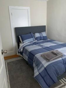 een slaapkamer met een bed met blauwe en witte lakens bij Cozy Cambridge Apt in Cambridge