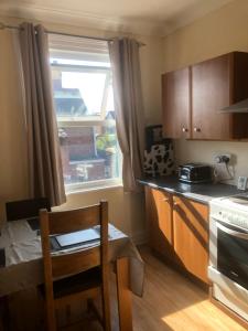 a kitchen with a table and a chair and a window at Chequers in Doncaster