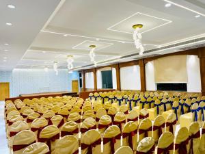 an empty hall with yellow chairs and tables at Hotel Park Airport Zone Hyderabad in Shamshabad