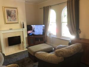 a living room with a tv and a couch and chairs at Chequers in Doncaster