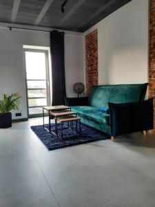 uma sala de estar com um sofá verde e uma mesa em Apartamenty Gliwice Staromiejska 65 em Gliwice