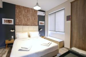 Un dormitorio con una gran cama blanca y una ventana en GK Ermou Str, en Atenas