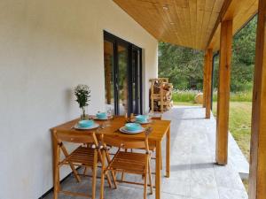 a wooden table and chairs on a patio at Mak i Rumianek in Parzeńsko