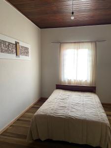 1 dormitorio con 1 cama grande y ventana en Recanto Luigi, en Rio dos Cedros