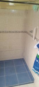 y baño con ducha y suelo de baldosa azul. en Alcobas con desayuno incluido baño compartido, en Medellín