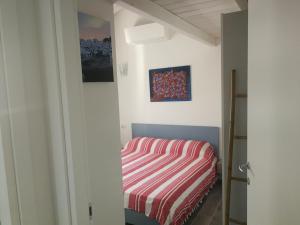 een kleine slaapkamer met een bed in een kamer bij Attico IL SOLE in Castelsardo