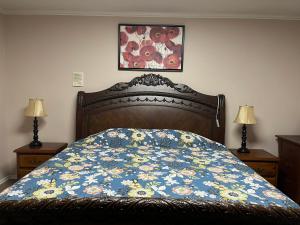 a bed with a blue comforter with flowers on it at Vancouver shaughnessy guest home in Vancouver