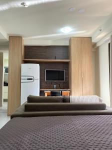 a bedroom with three brown beds and a refrigerator at Apartamento no Park Sul - Brasília in Brasilia