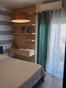 een slaapkamer met een bed, een raam en een lamp bij Sweet Home #Center# in Volos