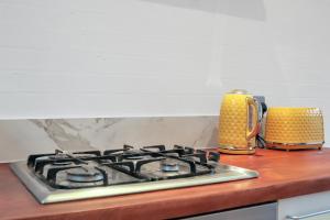 a stove top oven sitting on top of a kitchen counter at Stunning Shoreditch Loft Warehouse Style Apartment in London