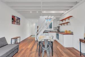 uma sala de estar e cozinha com uma mesa e um sofá em Stunning Shoreditch Loft Warehouse Style Apartment em Londres