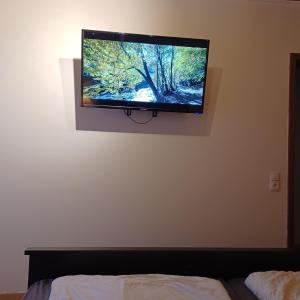 - une télévision à écran plat sur le mur d'une chambre dans l'établissement Wanderglück, à Braunlage