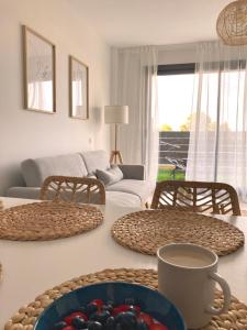 a living room with a table with a bowl of fruit on it at Ca La Cristina - Apartamento Turístico L'Ametlla de Mar in L'Ametlla de Mar