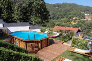 a backyard with a pool and a wooden deck at Bela Vista Urtigosa in Arouca