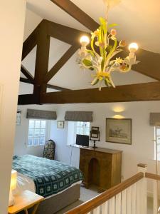 a bedroom with a bed and a chandelier at 2 Stable Cottage, Llanbethery in Llancarfan
