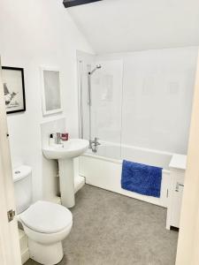 een witte badkamer met een toilet en een wastafel bij 2 Stable Cottage, Llanbethery in Llancarvan