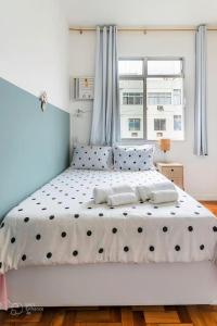 a bedroom with a large white bed with polka dots at Hotel Mama! Copacabana (Posto1 -Leme) in Rio de Janeiro
