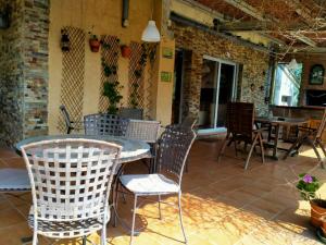 a patio with chairs and a table and tables at Twin Pines Camino Norte in Arzúa