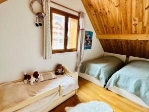 a bedroom with two beds and a cat sitting on a bed at Le Coucou - Grand chalet - Parking - WIFI - ALLOS - 10adul+2enf in Allos
