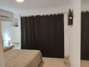 a bedroom with a bed and a black curtain at Monteagudo 847 in San Miguel de Tucumán