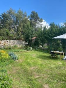 a picnic table and an umbrella in a yard at Maison cosy et calme 