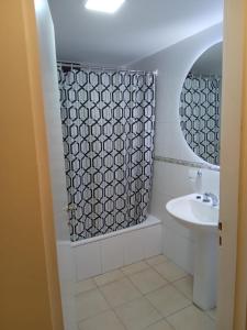 a bathroom with a sink and a shower curtain at Monteagudo 847 in San Miguel de Tucumán