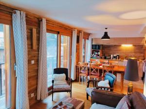 un soggiorno con divano e tavolo di Le Coucou - Grand chalet - Parking - WIFI - ALLOS - 10adul+2enf ad Allos