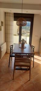 a table and a bench in a room with a window at El HOGAR DE LAS MARIPOSAS - VUTE-22-057 in Valdelinares