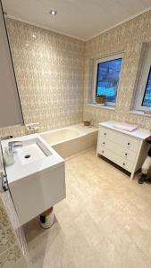 a bathroom with a white sink and a bath tub at Ferienhaus Lara in Feld am See