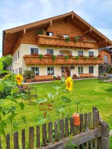 ein Haus mit einem Zaun und Blumen davor in der Unterkunft Ferienhaus Lenzenbauer in Salzburg