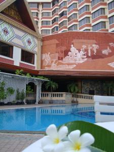 a hotel with a swimming pool in front of a building at Chiang Mai Phucome Hotel in Chiang Mai