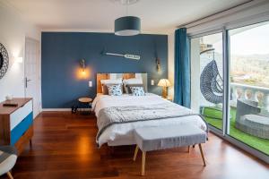 una camera con un grande letto con una parete blu di Ma villa au bord de l'eau a Miremont