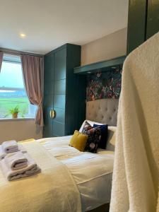 um quarto com uma cama grande e toalhas em Kennet House em Ludlow
