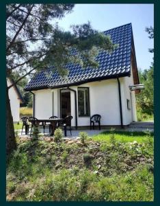 a house with a table and benches in front of it at Uroczy domek na Mazurach, Pilec 59 in Pilec +11 photos