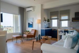 a living room with a white couch and a kitchen at Knots apartments in Ágios Nikólaos