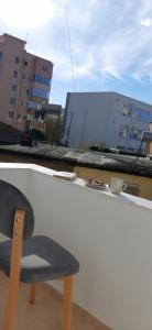 a chair sitting on the ledge of a building at Comfy apartment- Sunny balcony in Tirana