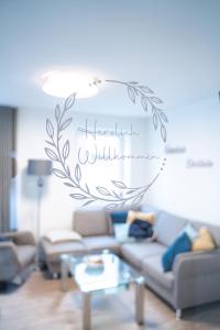 a living room with a couch and a sign on the wall at Urlaub an der Nordsee - NEU - Ferienhaus Deichliebe in Fedderwarderdeich